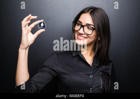 Femme d'affaires dans les verres avec Litecoin en mains isolé sur fond noir. Banque D'Images