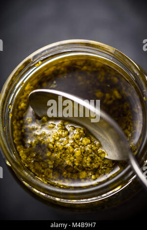 Sauce Pesto dans le bocal en verre avec verticale cuillère Banque D'Images