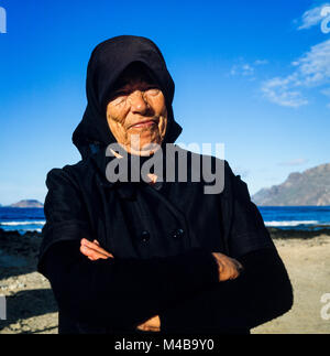 Des Canaries vieille femme vêtue de noir portant foulard sur une journée ensoleillée sur une plage Lanzarote probablement une veuve, photographié en janvier 1988 Banque D'Images