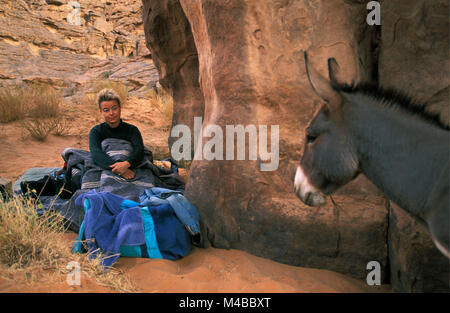 L'Algérie. Près de Djanet. Désert du Sahara. Plateau du Tassili. Âne. Femme tourisme camping et le réveil. Banque D'Images