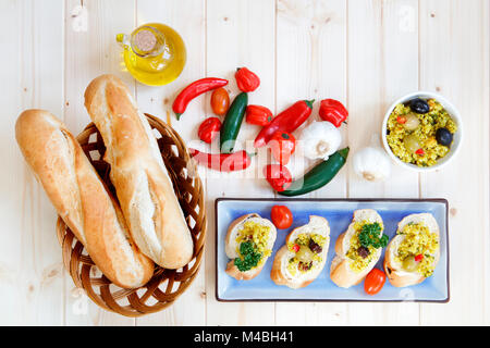 Dans le panier de petits pains à l'ail et huile d'olive sur la table en bois clair Banque D'Images