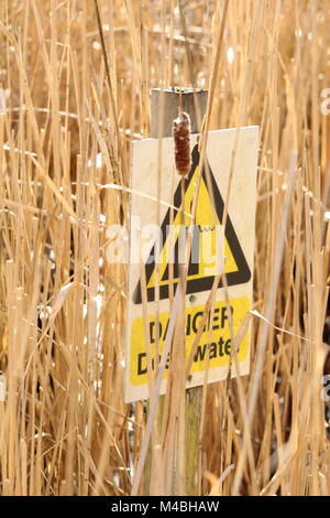 Le signe de danger - Danger de l'eau profonde à faune nature trail sur sentier en bois menant le long des roseaux et l'étang de Wat Tyler Country Park, dans l'Essex. Banque D'Images