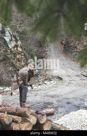 Les jeunes hommes sur des rondins dans la forêt. Pins Banque D'Images