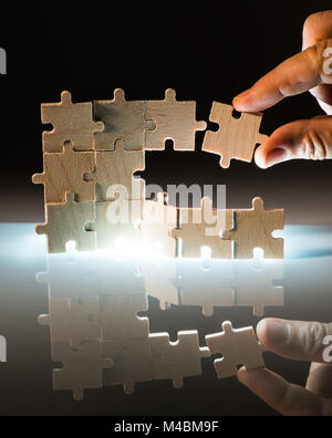 Puzzle en bois et l'éclairage de l'arrière-plan. Close up Banque D'Images