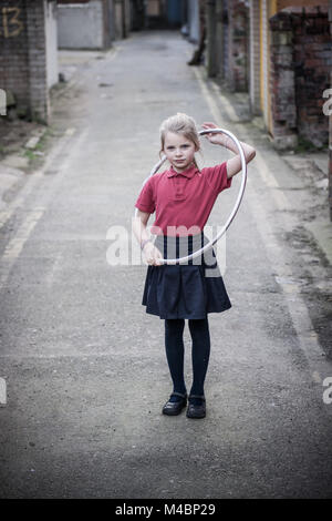 Fille jouant avec Hola Hoop dans la rue arrière de Blackpool uk Banque D'Images