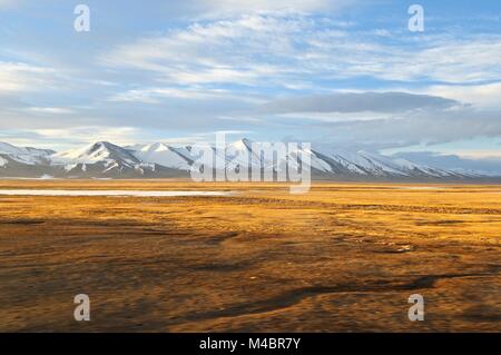 Montagnes couvertes de neige du haut plateau tibétain dans la lumière du soleil Banque D'Images