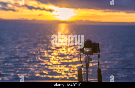 Coucher de soleil sur l'eau et un appareil photo DSLR Banque D'Images