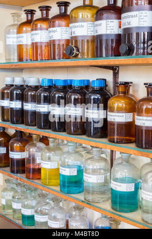 Lignes de produits chimiques liquides dans des bouteilles sur l'enseignement de la chimie Banque D'Images