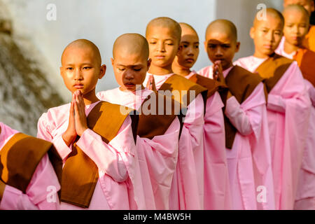 Portraits de jeunes nonnes bouddhistes, d'attente dans une longue rangée de recevoir des dons dans un monastère Banque D'Images