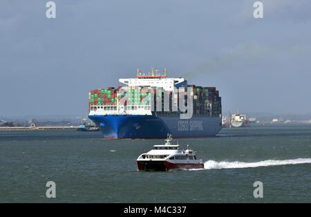 Un énorme navire quittant le port de Southampton SOUTHAMPTON docks d'être adopté par de l'eau jet rouge île de Wight service des ferries red funnel de Cowes. Banque D'Images