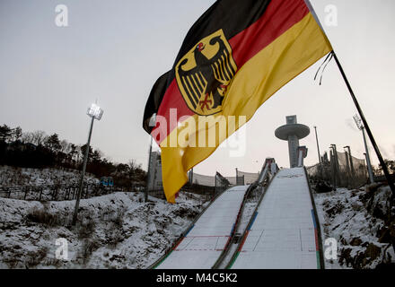 Allgemein, fonction, Randmotiv, die deutsche Flagge weht im Wind, im Hintergrund die beiden, Sprungschanzen Nordische Kombination der Maenner, Combiné nordique - Ind. Gund. NH/10km, Cross-Country am 14.02.2018, Alpensia Ski Center Olympische Winterspiele 2018, vom 09.02. - 25.02.2018 à PyeongChang/ Suedkorea. Dans le monde d'utilisation | Banque D'Images