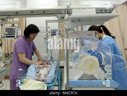 Shanghai, Chine. Feb 15, 2018. Infirmière-chef Li Liling(R) s'occupe de l'utilisation d'un patient à l'unité de soins intensifs néonatals (USIN) à l'Hôpital pour enfants de l'Université Fudan à Shanghai, la Chine orientale, le 15 février 2018. Les travailleurs médicaux ici collé à leurs postes à la veille du Nouvel An chinois pour prendre soin des patients. Credit : Liu Ying/Xinhua/Alamy Live News Banque D'Images