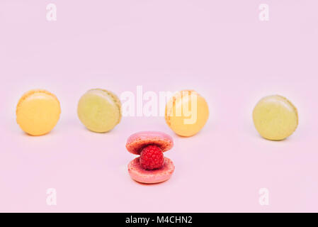 Macarons gâteau macaron français comme un coquillage avec perle de framboise. Banque D'Images