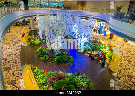 Singapour - circa 2016, août : au-dessus de la vue des personnes non identifiées, assis sur une des chaises dans un petit jardin avec des plantes à l'intérieur de l'aéroport Singapour Changi Banque D'Images