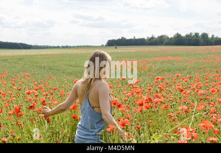 Femme en champ de coquelicots Banque D'Images