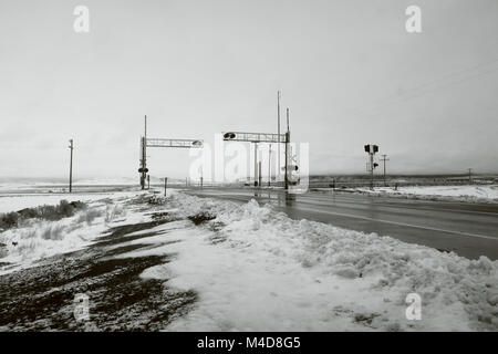 Un passage à niveau en hiver en noir et blanc. Banque D'Images