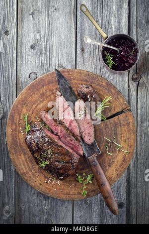 Barbecue steak de chevreuil sur la vieille planche à découper Banque D'Images