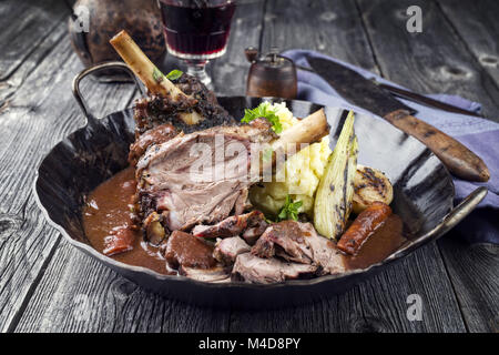 Knuckles l'agneau avec légumes en sauce au vin rouge Banque D'Images