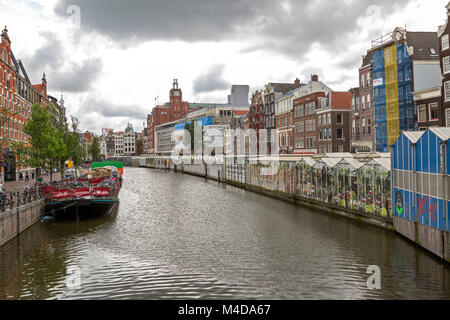 Vue sur le canal avec le célèbre marché aux fleurs flottant sur un côté et ferry pour les vélos de l'autre. Banque D'Images