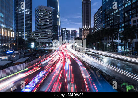 Capturé avec trafic blurred motion se précipiter sur la principale avenue dans le quartier des affaires de Jakarta la nuit en Indonésie capitale Banque D'Images