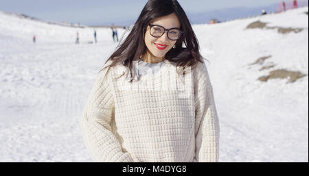 Young smiling woman in sweater sur la pente de ski Banque D'Images