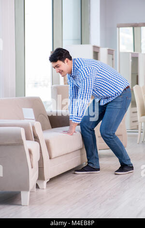 Young man shopping in furniture store Banque D'Images