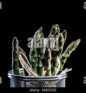 D'asperge dans un panier métallique sur fond noir Banque D'Images