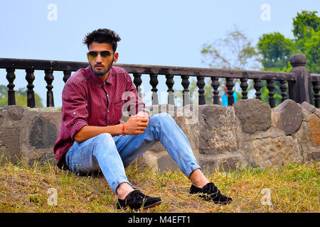 Jeune homme à la chemise à carreaux et des lunettes de soleil, Pune, Maharashtra. Banque D'Images