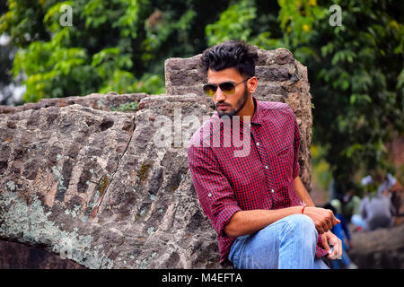 Jeune homme à la chemise à carreaux et des lunettes de soleil, Pune, Maharashtra. Banque D'Images