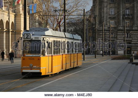 Un tramway jaune passe par une artère principale à Budapest, en Hongrie, un jour d'hiver. Banque D'Images