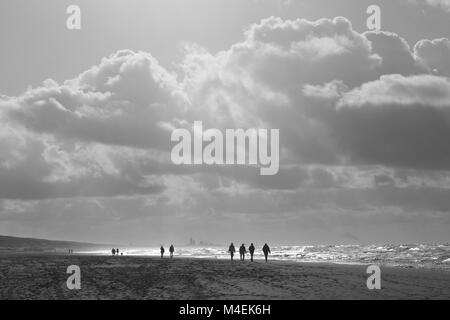Capture de contre-jour des marcheurs silhouettés sur la plage de Katwijk, Hollande du Sud, pays-Bas, Europe. Banque D'Images