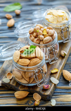 Amandes, pistaches et amandes flakes dans un bocal en verre. Banque D'Images