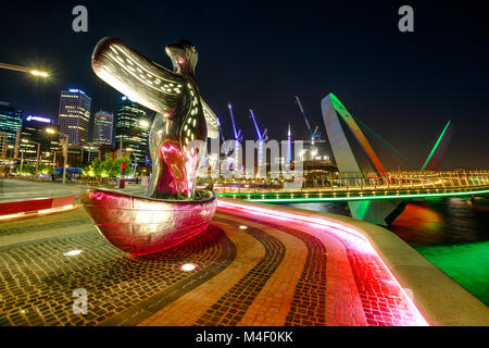 Perth, Australie - Jan 5, 2018 : Premier Contact Sculpture sur le premier plan à Elizabeth Quay Marina est éclairée la nuit. Les grues de construction et d'arcade de l'Elizabeth Quay Pont sur l'arrière-plan. Banque D'Images