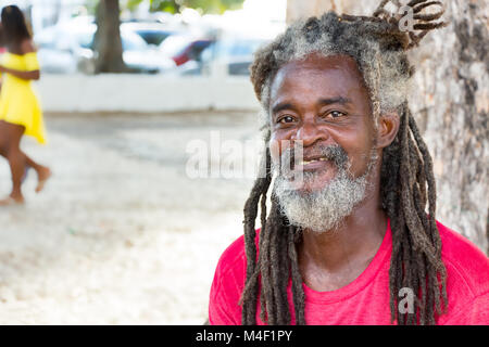 Salvador de Bahia, Brésil - Février 11th, 2018 : Portrait d'un homme avec la peau foncée Bahiano et cheveux longs dreadlocks au bord de l'eau du port de Banque D'Images