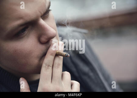 Guy fume une cigarette à l'extérieur, portrait, close-up Banque D'Images