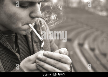 Guy fume une cigarette à l'extérieur, portrait, close-up Banque D'Images