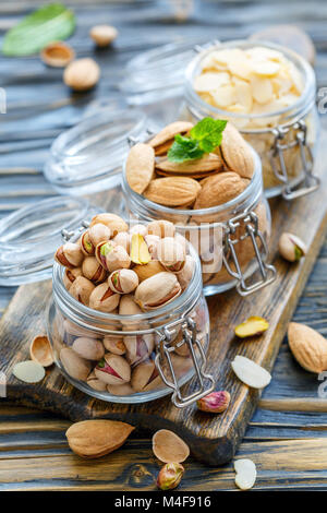 Flocons d'amandes, pistaches et amandes dans les bocaux. Banque D'Images