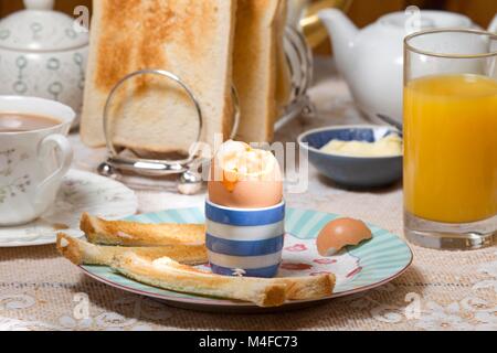 Paramètres de petit-déjeuner avec oeuf mollet et beurrée pour tremper Banque D'Images