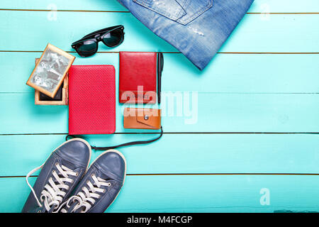 Set de voyage, Passeport, e-book, chaussures, lunettes de soleil, appareil photo. on a wooden surface turquoise, une vue de dessus Banque D'Images