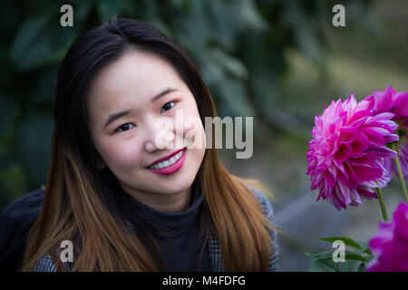 Belle femme posant à côté de fleur pourpre dans un jardin japonais Banque D'Images