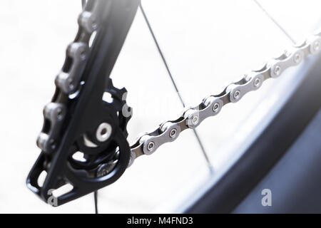 Roue et équipement de vélo avec une nouvelle chaîne propre, rayons et petite bague de chaîne du commutateur de vitesse de vélo de montagne arrière sur un fond blanc Banque D'Images