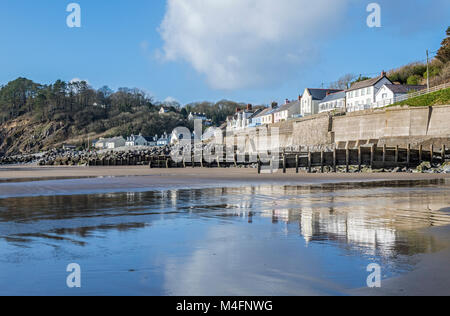 Amroth Village sur la côte de Pembrokeshire sud reflète dans la plage du sable mouillé, West Wales Banque D'Images