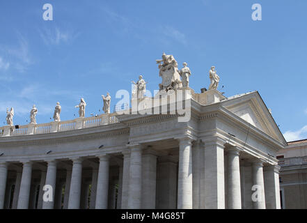 Statues sur le dessus de l'aile droite de la Place Saint-Pierre, les Colonnades against blue sky, Cité du Vatican, Rome, Italie. Banque D'Images