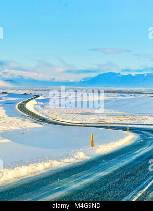 Conduite de voiture sur la route glacée en hiver sur le plateau en Islande. Banque D'Images