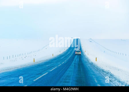 Conduite de voiture sur la route glacée en hiver sur le plateau en Islande. Banque D'Images