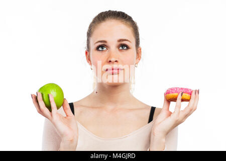 Portrait d'une belle jeune fille avec une pomme verte et un beigne, isolated on white Banque D'Images