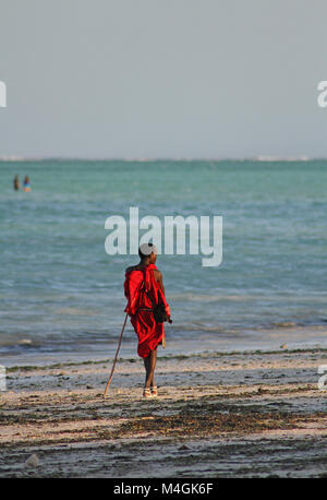 Homme massaï debout sur la plage au coucher du soleil, plage de Nungwi, Zanzibar, Tanzanie Banque D'Images