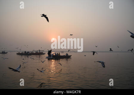 Scène tôt le matin avec des oiseaux et des bateaux, à Varanasi Banque D'Images