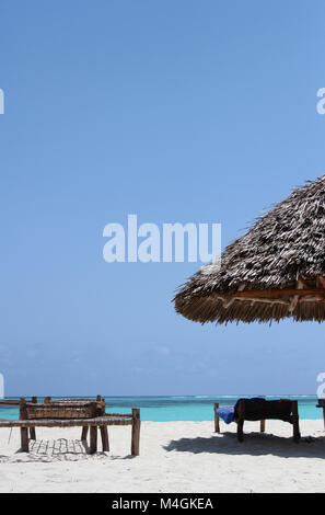 Les lits de bronzage et parasol sur la plage, plage de Nungwi, Zanzibar, Tanzanie Banque D'Images