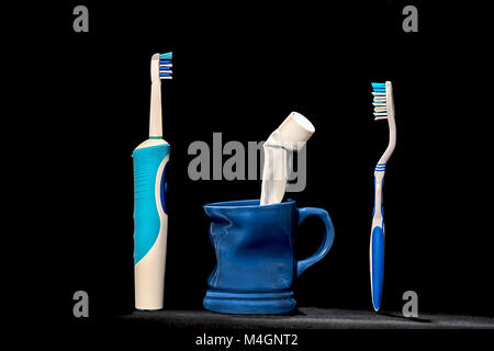 Brosse à dents traditionnelle et moderne avec cruche avec du dentifrice isolé sur fond noir/oral hygiene Banque D'Images